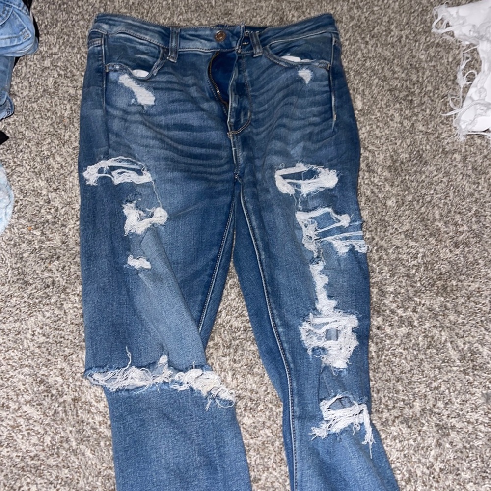 Blue jeans, stretchy. super-high rise jeggings. Rips in the front and back